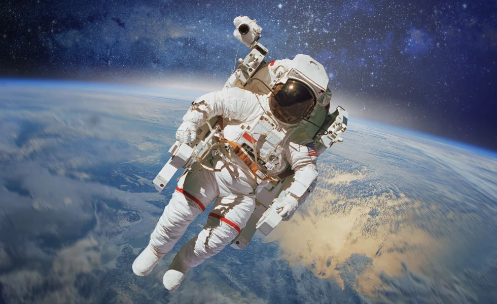 Astronauta w kombinezonie dryfujący w kosmosie na tle planety Ziemia