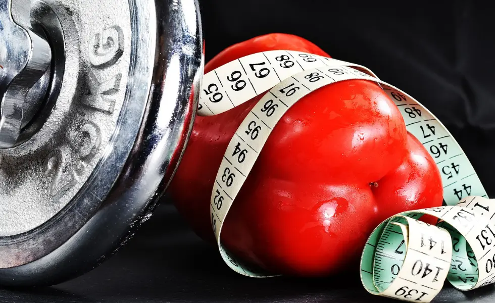 Czerwona papryka z miarką krawiecką i ciężarkiem 